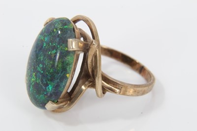 Lot 33 - Black opal single stone ring with an oval black opal cabochon measuring approximately 20mm x 13mm x 4.2mm in a 9ct gold setting. Ring size O.