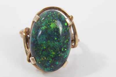 Lot 33 - Black opal single stone ring with an oval black opal cabochon measuring approximately 20mm x 13mm x 4.2mm in a 9ct gold setting. Ring size O.