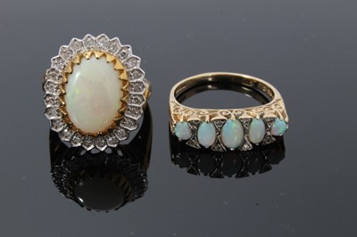 Lot 34 - Two 9ct gold and diamond dress rings, one with an oval opal cabochon measuring approximately 13.5mm x 9.7mm surrounded by a border of single cut diamonds, size N, the other ring with five graduated...