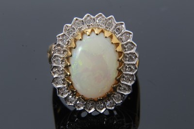 Lot 34 - Two 9ct gold and diamond dress rings, one with an oval opal cabochon measuring approximately 13.5mm x 9.7mm surrounded by a border of single cut diamonds, size N, the other ring with five graduated...