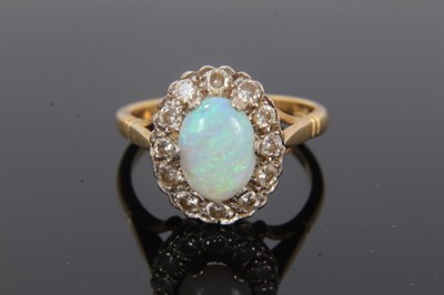 Lot 41 - Opal and diamond cluster ring with an oval cabochon opal measuring approximately 8.9mm x 6.4mm x 2.1mm, surrounded by a border of twelve brilliant cut diamonds on 18ct gold shank. Estimated total d...