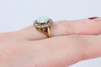 Lot 41 - Opal and diamond cluster ring with an oval cabochon opal measuring approximately 8.9mm x 6.4mm x 2.1mm, surrounded by a border of twelve brilliant cut diamonds on 18ct gold shank. Estimated total d...
