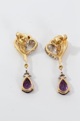 Lot 43 - Pair of 18ct gold diamond and amethyst pendant earrings with a pear cut amethyst surmounted by three diamonds suspended from a gold diamond-set scroll. 33mm