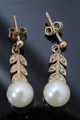 Lot 44 - Pair of cultured pearl and diamond pendant earrings with a 7mm cultured pearl suspended from stylized diamond foliage in 9ct gold setting. 21mm