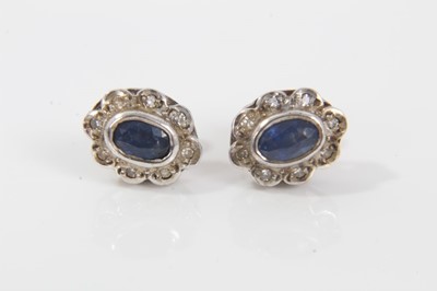 Lot 45 - Pair of sapphire and diamond cluster earrings, each with an oval mixed cut blue sapphire surrounded by a border of single cut diamonds. 9.8mm x 7.8mm