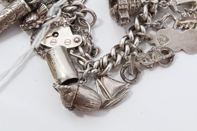Lot 232 - Silver charm bracelet with a collection of silver and white metal charm and padlock clasp.