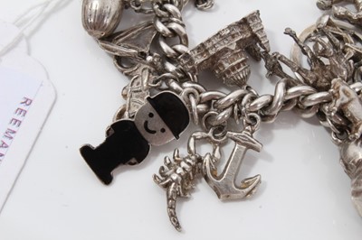 Lot 232 - Silver charm bracelet with a collection of silver and white metal charm and padlock clasp.