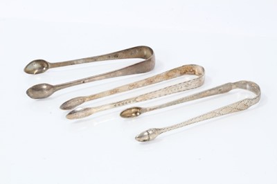 Lot 352 - Two Georgian silver bright cut sugar tongs and another plain pair (3)