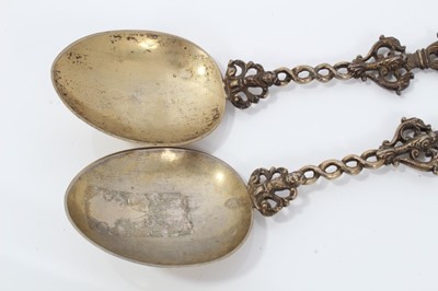 Lot 353 - Pair ornate 19th century Dutch silver gilt serving spoons with cast figure terminals and dolfin decoration 20 cm