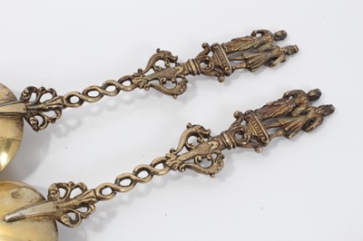 Lot 353 - Pair ornate 19th century Dutch silver gilt serving spoons with cast figure terminals and dolfin decoration 20 cm