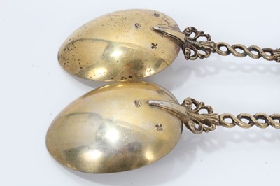 Lot 353 - Pair ornate 19th century Dutch silver gilt serving spoons with cast figure terminals and dolfin decoration 20 cm