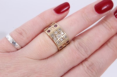 Lot 245 - Diamond and ruby ring with a wide 9ct yellow gold band with brilliant cut diamonds and mixed cut rubies in a grid-style setting.