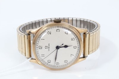 Lot 265 - 1950s gentlemans Omega 9ct gold wristwatch with silvered dial, centre seconds, bubble back to case on plated expanding bracelet. The case 35mm.