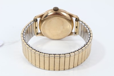 Lot 265 - 1950s gentlemans Omega 9ct gold wristwatch with silvered dial, centre seconds, bubble back to case on plated expanding bracelet. The case 35mm.