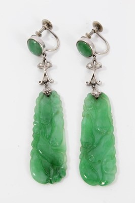 Lot 312 - Pair of Chinese carved green jade pendant earrings, each with a carved and pierced jade plaque suspended from a jade cabochon, all with 9ct white gold and diamond mounts. 57mm length.