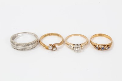 Lot 321 - Four gold and gem-set rings to include a diamond two-stone cross-over ring (Birmingham 1913) size M, diamond single stone ring in 14ct gold setting, 18ct gold sapphire and diamond ring (Chester 191...