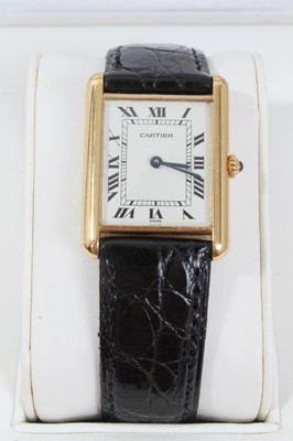 Lot 310 - Cartier 18ct gold Tank Quartz wristwatch, the rectangular white dial with black enamel Roman numerals and blued steel hands, in 18ct gold tank shaped case, cabochon blue sapphire to the crown, on C...