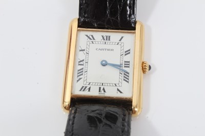 Lot 310 - Cartier 18ct gold Tank Quartz wristwatch, the rectangular white dial with black enamel Roman numerals and blued steel hands, in 18ct gold tank shaped case, cabochon blue sapphire to the crown, on C...