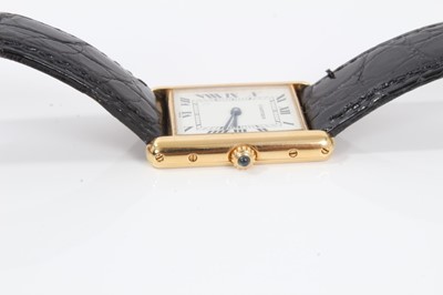 Lot 310 - Cartier 18ct gold Tank Quartz wristwatch, the rectangular white dial with black enamel Roman numerals and blued steel hands, in 18ct gold tank shaped case, cabochon blue sapphire to the crown, on C...