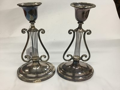 Lot 687 - Pair of late Victorian silver candlesticks with lyre support, on oval bases, London 1900 (one broken)