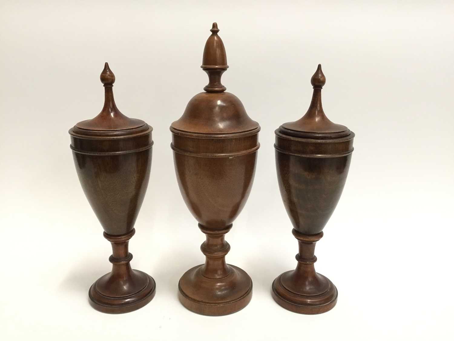 Lot 128 - Trio of decorative treen urns and covers of classical form