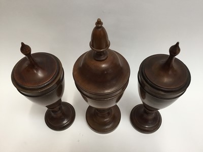 Lot 128 - Trio of decorative treen urns and covers of classical form