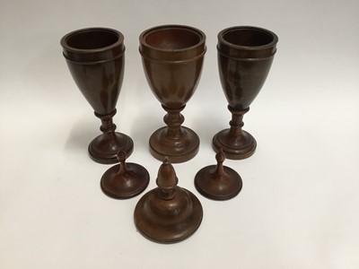 Lot 128 - Trio of decorative treen urns and covers of classical form