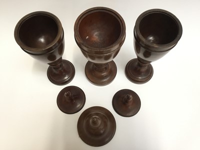 Lot 128 - Trio of decorative treen urns and covers of classical form
