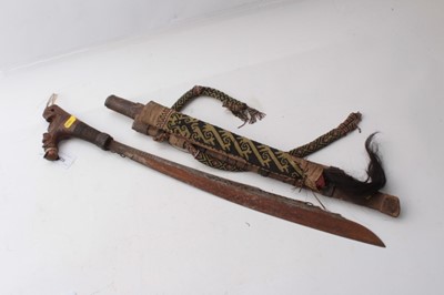 Lot 335 - Early 20th century Borneo Dayak Mandau headhunters sword with carved wood and woven hair hilt , curved blade with engraved decoration in carved wood sheath with dyed bristle and woven decoration an...