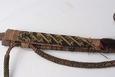 Lot 335 - Early 20th century Borneo Dayak Mandau headhunters sword with carved wood and woven hair hilt , curved blade with engraved decoration in carved wood sheath with dyed bristle and woven decoration an...