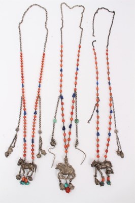 Lot 44 - Three old Chinese coral bead necklaces with white metal horse pendants