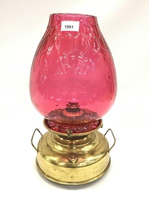 Lot 1981 - Early 20th century brass oil lamp with cranberry glass shade