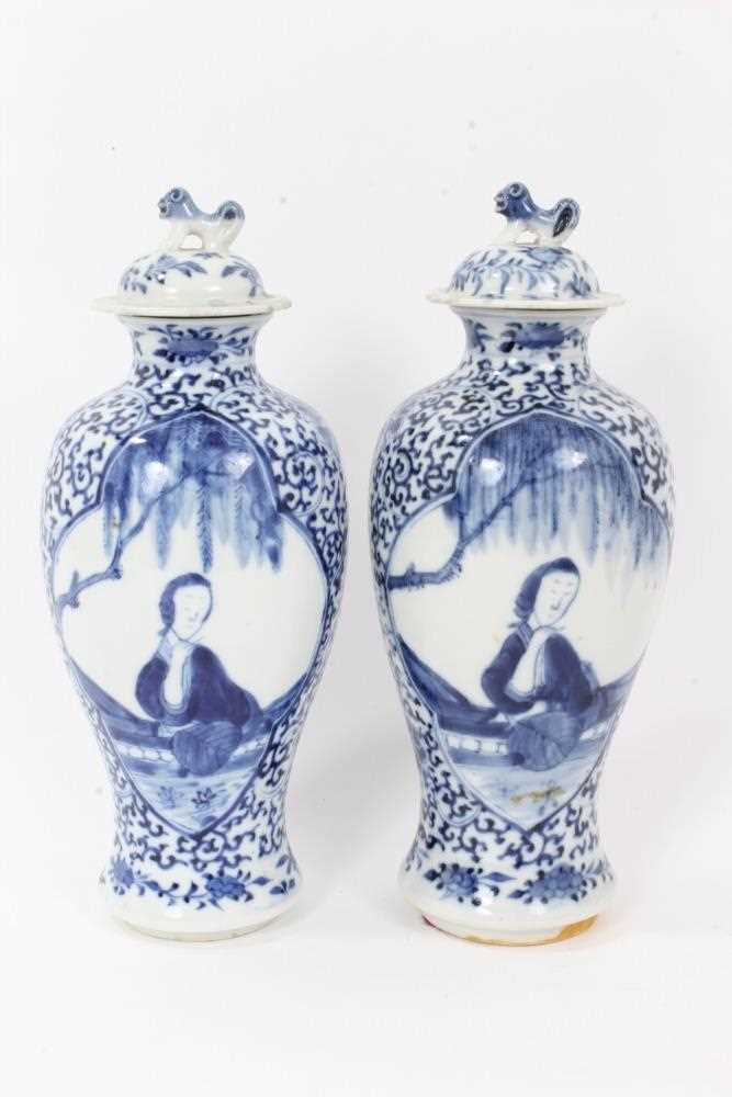 Lot 8 - Pair 19th century Chinese blue and white porcelain baluster vases and cover, decorated with figural panels on a foliate patterned ground