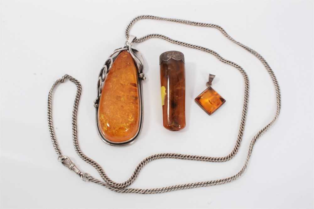 Lot 114 - Large silver mounted amber pendant on silver chain, one other amber pendant and amber cheroot
