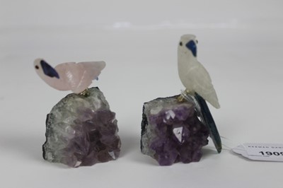 Lot 1909 - A carved rose quartz parrot perched upon an amethyst crystal geode, and a similar white stone carved parrot, 7cm and 8.5cm height