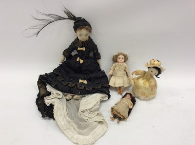 Lot 1561 - Three Victorian dolls, including one kid leather doll in Victorian dress, one small bisque doll with painted features and boots and a small bisque head doll with composite body and limbs.