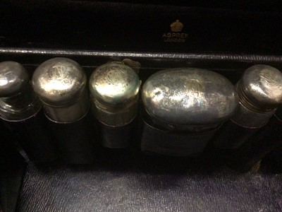 Lot 1828 - Early 20th Century Navy Blue leather travelling vanity case containing a selection of silver topped bottles, by Asprey & Co, with gilt monogram 'C. W.' to lid.