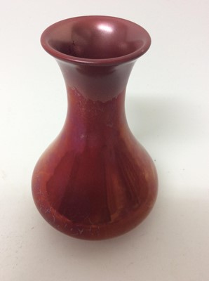Lot 653 - Carters Poole red lustre vase c.1906 and two bluebird pattern Poole vases, the largest measuring 16cm height (3)