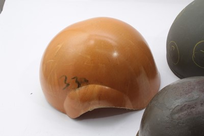 Lot 263 - American M1 Steel helmet reworked for the Korean War, together with another M1 steel helmet and two helmet shells (4)