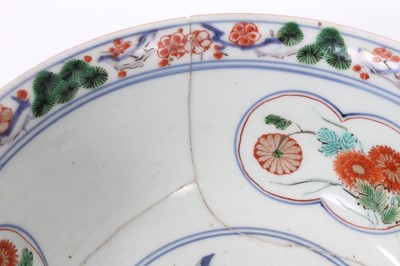 Lot 22 - Early Japanese Edo period Imari dish, c.1700, painted with vases of flowers, further floral patterns, and two phoenixes around the edge, repaired, 32cm diameter