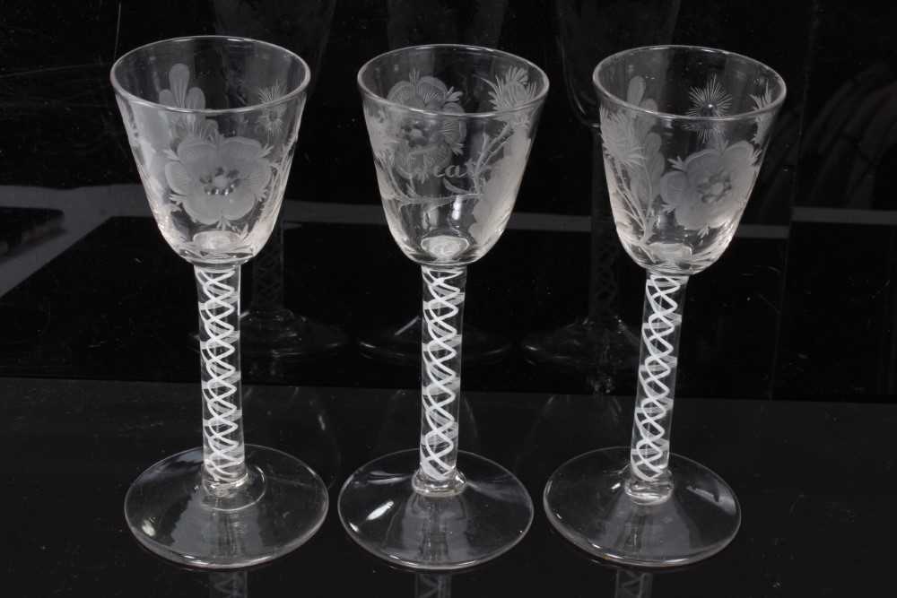Lot 38 - Georgian cordial glasses comprising a pair with Jacobite engraved rose, thistle, star and leaf decoration with double series opaque twist stems and an identical glass with similar decoration with F...