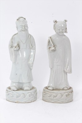 Lot 42 - Good pair of antique Chinese Qing period blanc de chine figures, the female figure carrying a fly whisk, the male figure carrying a piece of fruit, both standing on bases with stylised waves, 21.5c...
