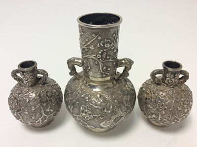 Lot 166 - Pair of late 19th century Chinese silver bottle vases with chased and embossed decoration of prunus, character marks to bases for Wang Hing