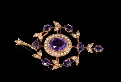 Lot 354 - Edwardian amethyst and seed pearl pendant/brooch with a central oval cluster within a wreath design with pendant fitting sand drop. 52mm x 30mm