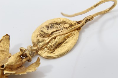 Lot 388 - Antique or possibly ancient gold earring, modelled as Eros or Cupid, the winged figure suspended from a rosette with hook fitting. Possibly Greek Hellenistic period circa 3rd or 4th century B.C. or...