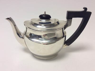 Lot 156 - George V silver teapot of oval form, domed hinged cover with ebony knop and angular ebonised handle, (London 1920), maker George Unite, 22cm from handle to spout, all at approximately 15oz