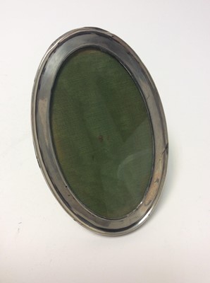 Lot 163 - George V silver photograph frame of rectangular form with rounded corners (Birmingham 1918), together with a George V silver photograph frame of oval form (Birmingham 1920)
