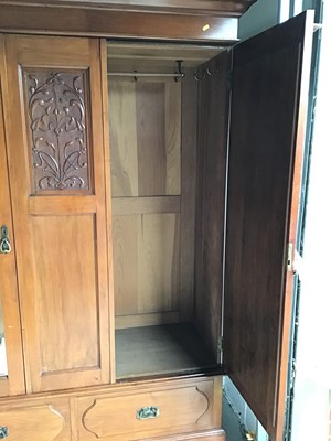Lot 10 - Art Nouveau mahogany wardrobe, with moulded cornice and twin mirrored doors between relief carved foliate panel and two drawers below on plinth base, 148cm wide x 54cm deep x 201cm high