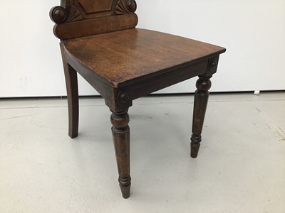 Lot 15 - Regency mahogany hall chair, the arched panel back centred by recessed circular painted armorial crest roundel and solid seat on facetted legs, restorations