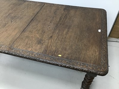 Lot 86 - Early 20th century oak extending dining table, the rounded rectangular wind out top with relief carved scroll border on barley twist legs abc castors, with two additional leaves 180 x 105cm extendi...